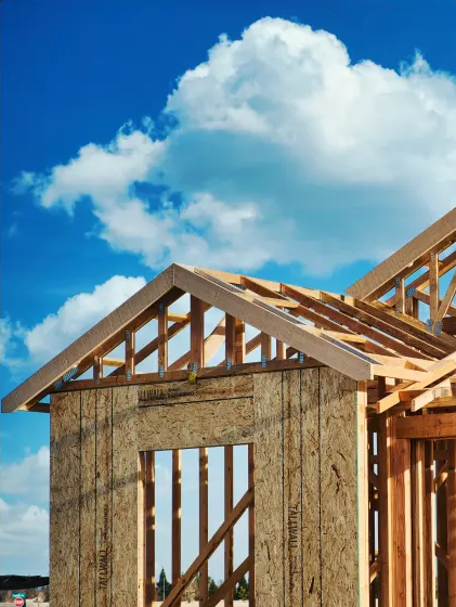 New house frame under a cloudy blue sky